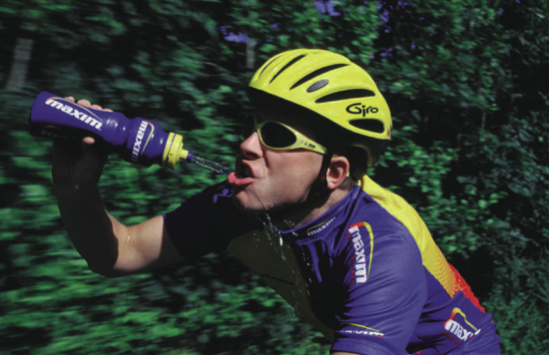 Homme pédalant à vélo en buvant dans sa gourde